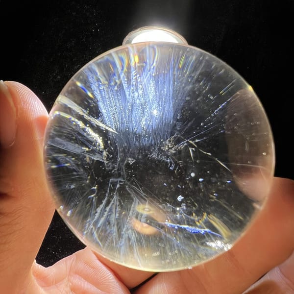 Starburst of blue needles spreading from the middle of the clear sphere
