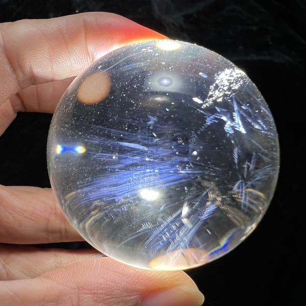 Sweeping blue sprays and a white sparkle cluster near the sphere rim