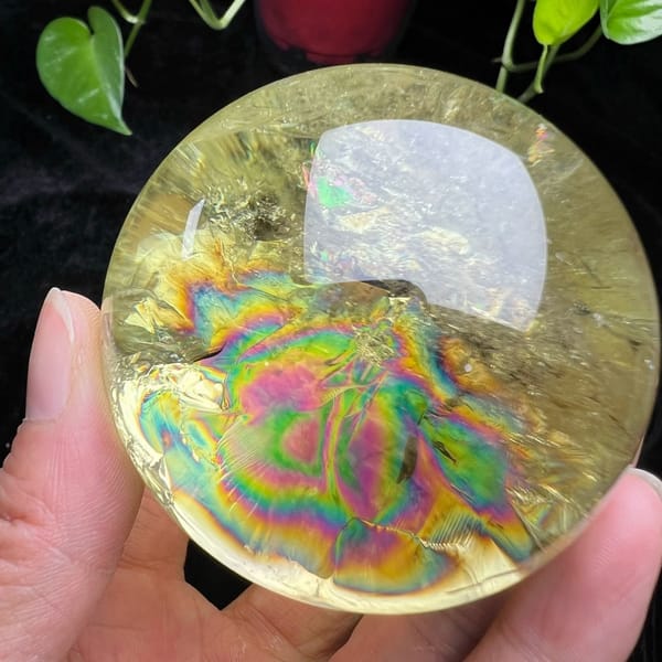 Lemon citrine sphere with a large ring-shaped rainbow filling its centre
