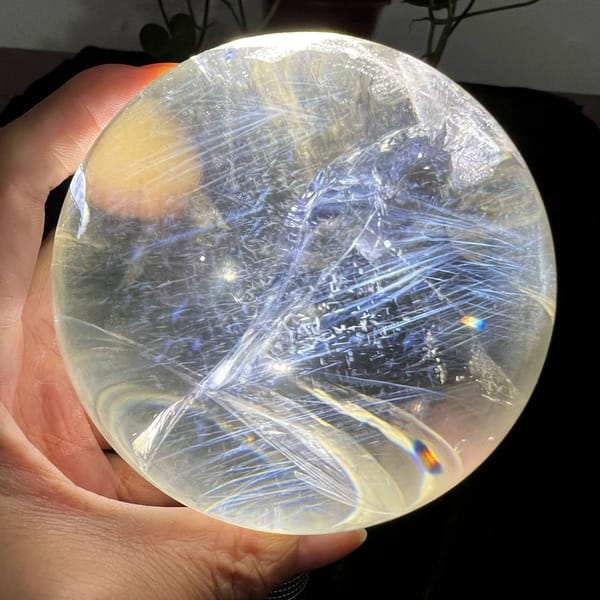 Sweeping blue feather sprays crossing the clear quartz from upper left