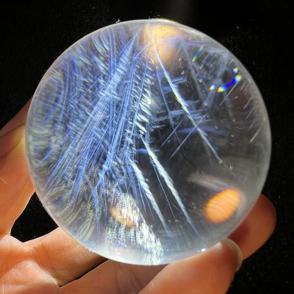 Long blue sprays with side branches angling across the lit sphere