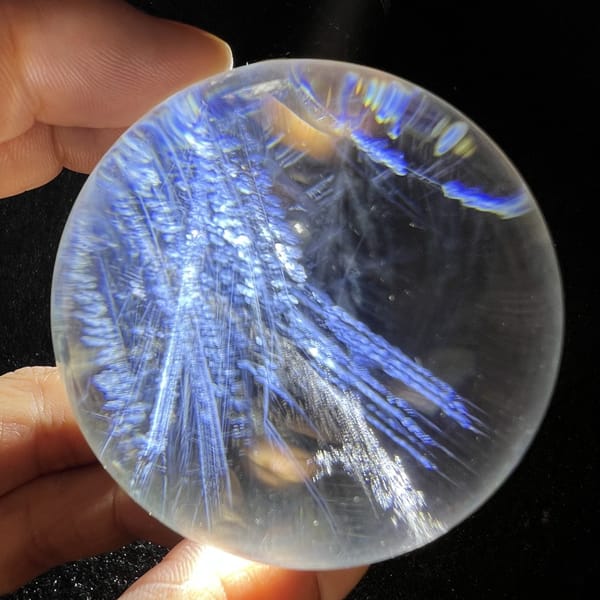 Feather sprays fanning from the upper left of the sphere