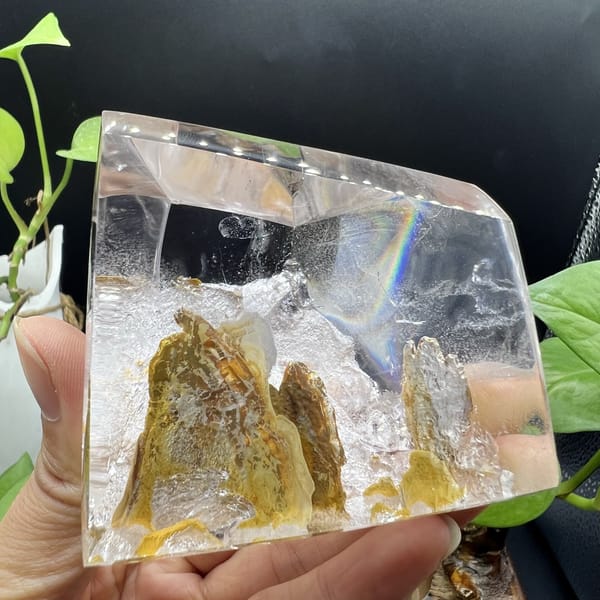 Rainbow flash above the golden mountain scene in the clear quartz