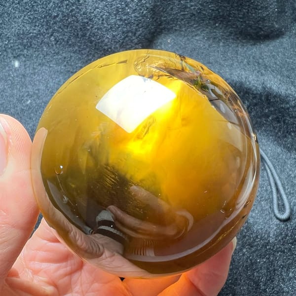 Bright golden yellow face of the sphere lit from behind