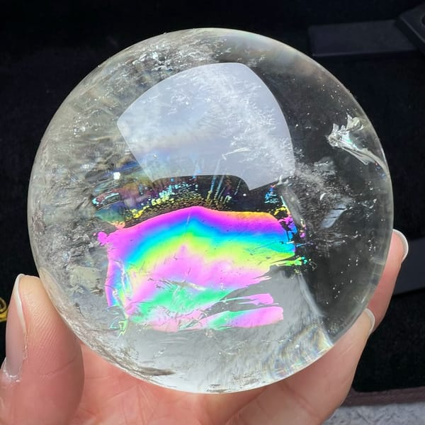 Pale citrine sphere with a wide rainbow band glowing across its centre