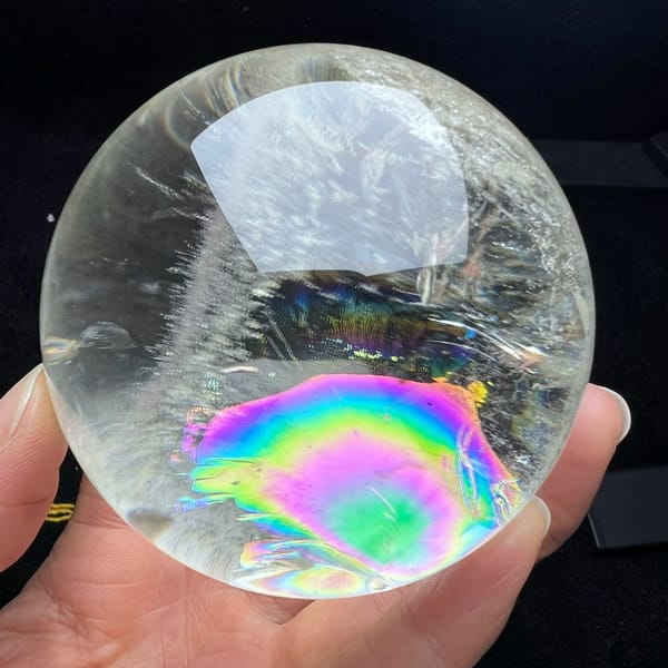 Concentric rainbow rings with a green core in the lower half of the sphere