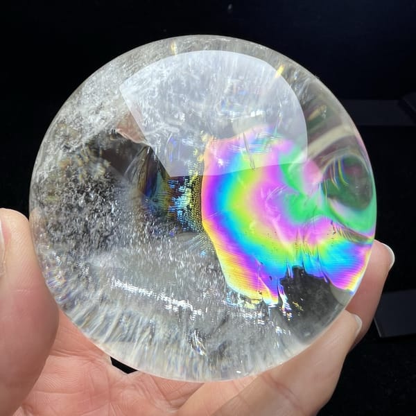 Large rainbow with a pink centre and green rings at right