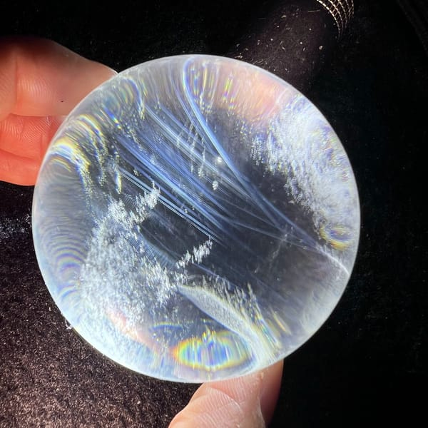 Curving blue needles and snowy patches with a rainbow ring at the base
