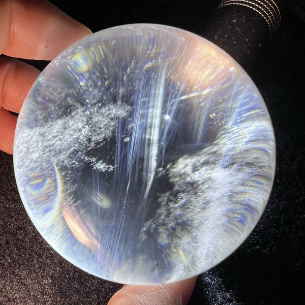 Long blue streaks reaching across the sphere beside a white cloud