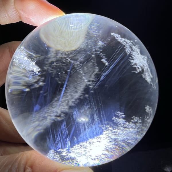 Blue needles running beneath a diagonal band of white inclusions