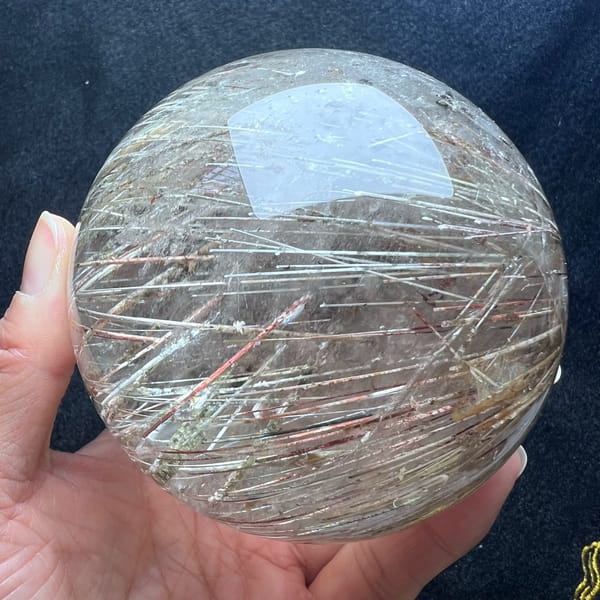 Crisscrossing coarse rutile needles in red, gold and silver tones