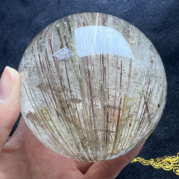 Upright rutile needles with a golden mica flake at the top