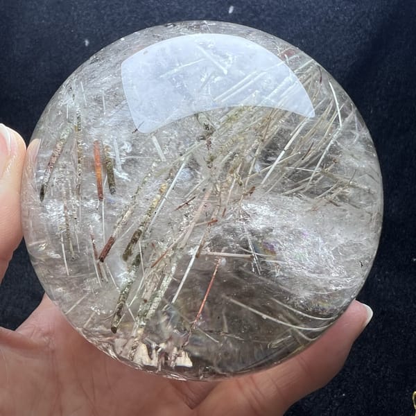 Coarse needles crossing a white cloudy patch inside the sphere