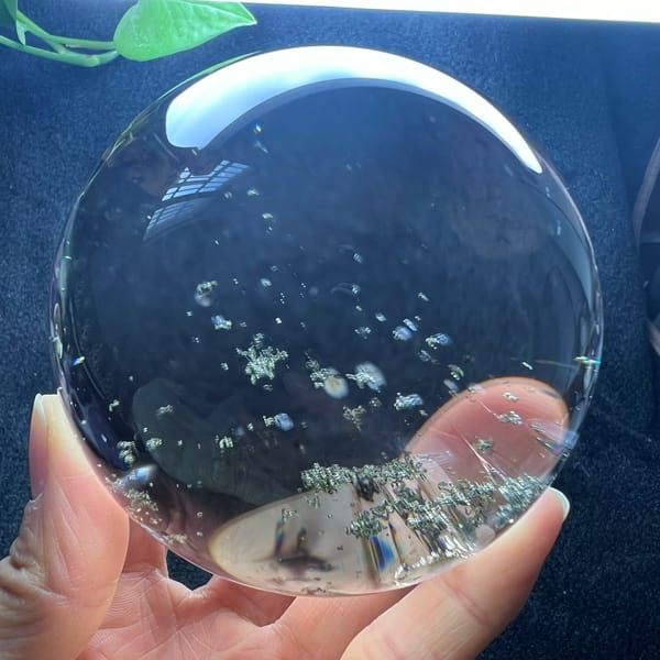 Sparse green flecks floating in transparent smoky quartz