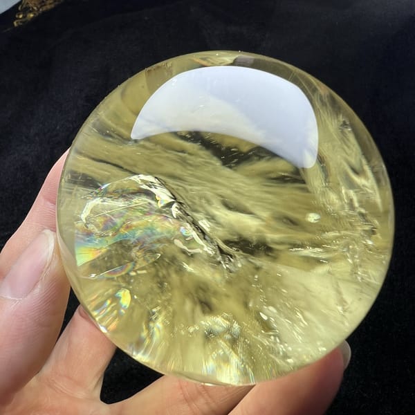 Wispy internal planes catching light across the citrine sphere