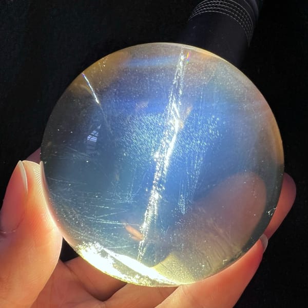 Torch-lit citrine sphere glowing blue with a bright diagonal internal line