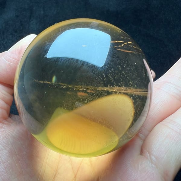 Pale citrine sphere showing a golden glow in its lower half