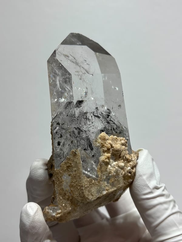 Old-find Jinkouhe quartz with black phantom and calcite from Sichuan, China, held in gloved hand