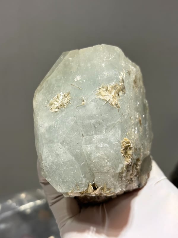 Large single aquamarine crystal with unusual etched pattern from Sichuan, China, front view in daylight, held in hand