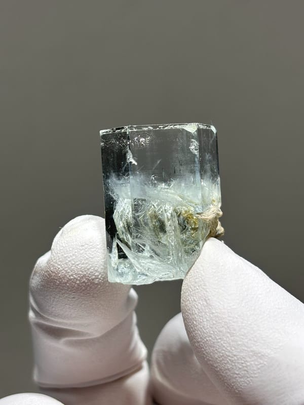 Gem aquamarine with mica grown half inside it from Pakistan, close-up of the crystal faces
