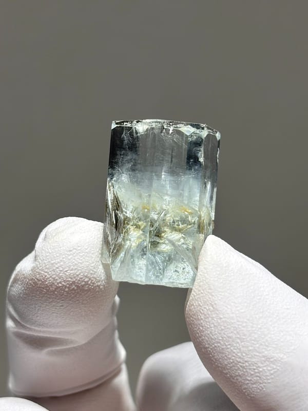 Gem aquamarine with mica grown half inside it from Pakistan, reverse side