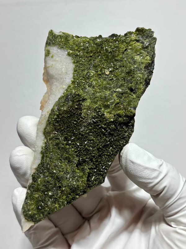 Plate of green epidote and quartz on tan matrix from Sichuan, China, close-up of the crystal faces