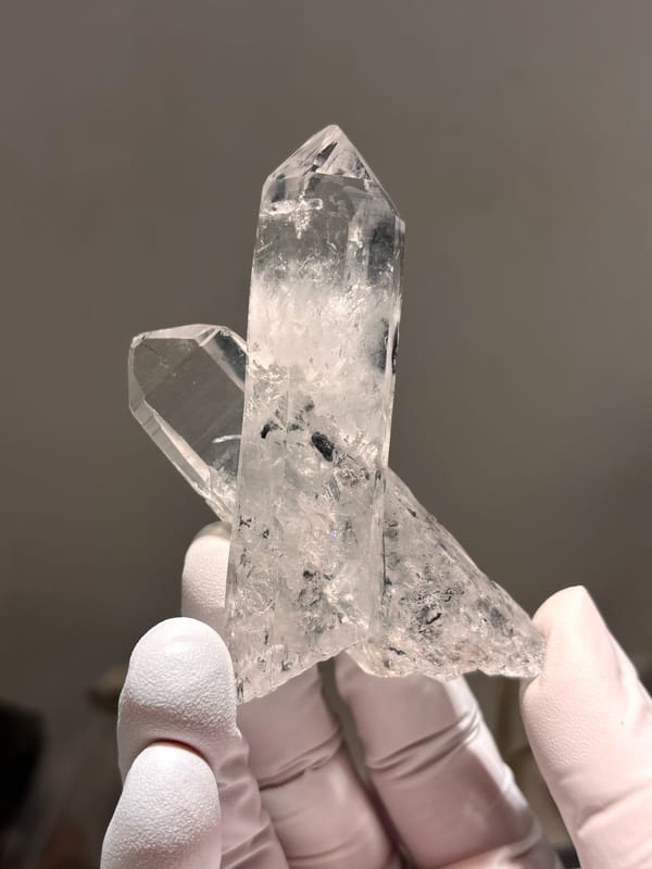 Two crossed clear quartz points with complete tips from Jinkouhe, Sichuan, China, close-up of the crystal faces