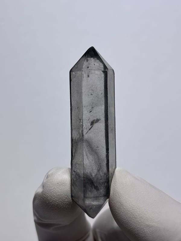 Grey double-terminated quartz wand from Yunnan, China, close-up of the crystal faces