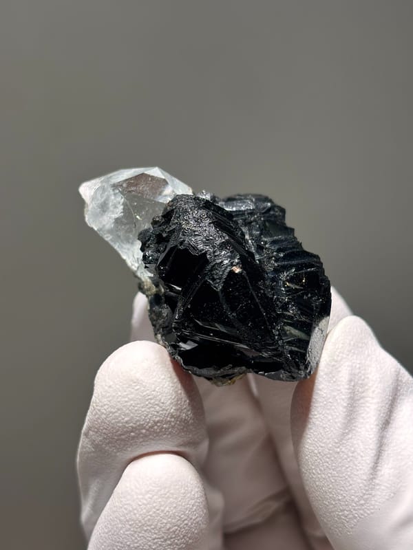 Pale aquamarine on black cassiterite from Xuebaoding, Sichuan, China, close-up of the crystal faces