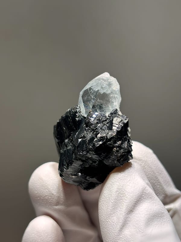 Pale aquamarine on black cassiterite from Xuebaoding, Sichuan, China, top view