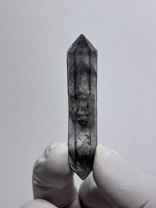 Dark smoky double-terminated quartz wand from Yunnan, China, close-up of the crystal faces