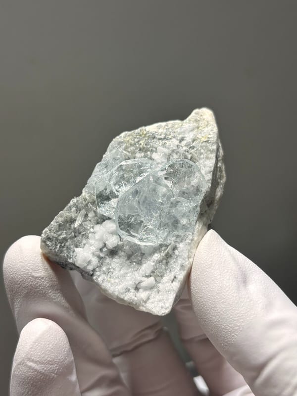 Heart-shaped aquamarine on white feldspar from Xuebaoding, Sichuan, China, close-up of the crystal faces