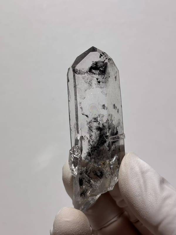 Clear quartz point with black inclusions and complete tip from Jinkouhe, Sichuan, China, second angle