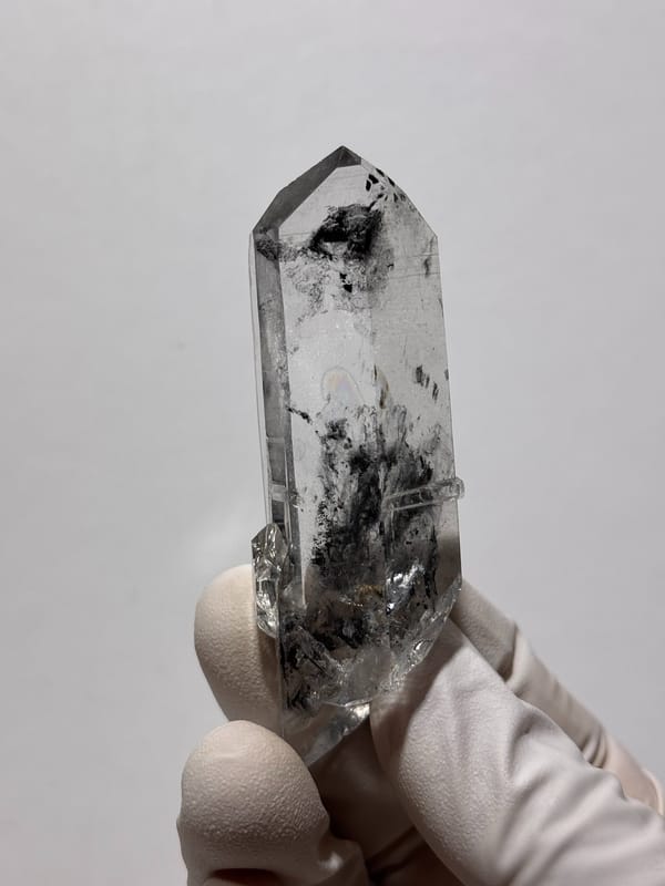 Clear quartz point with black inclusions and complete tip from Jinkouhe, Sichuan, China, reverse side