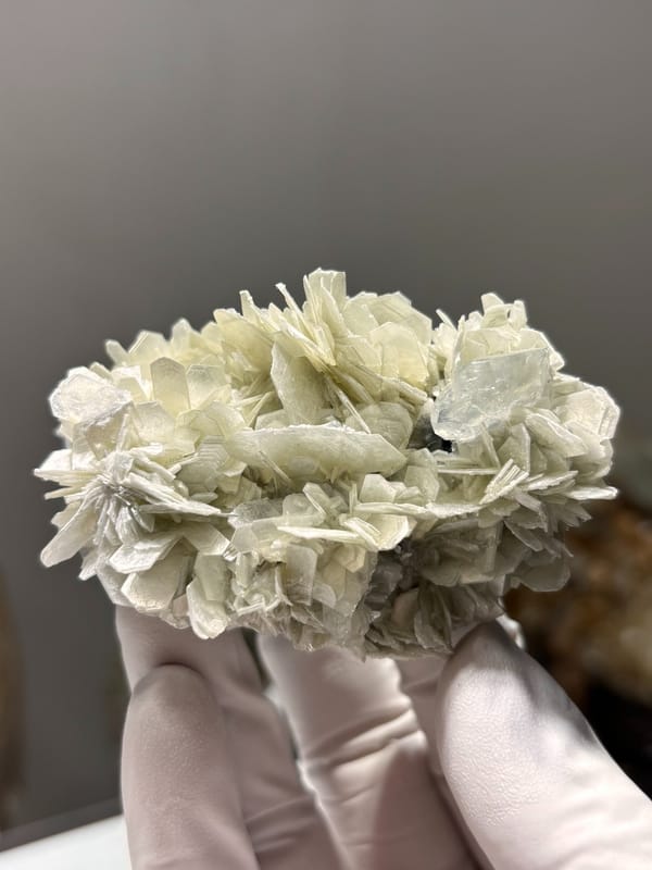Cluster of pale mica rosettes with aquamarine from Xuebaoding, Sichuan, China, close-up of the crystal faces