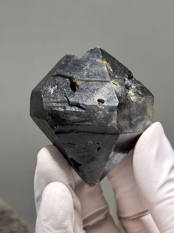 Stout jet-black double-terminated quartz from Guizhou, China, detail of the matrix contact