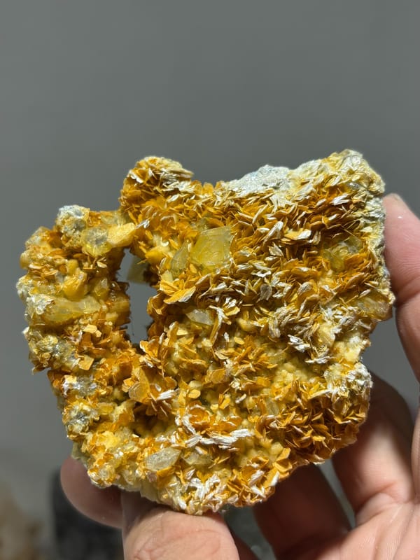 Pale aquamarine in golden mica with natural hollow from Xuebaoding, Sichuan, China, close-up of the crystal faces