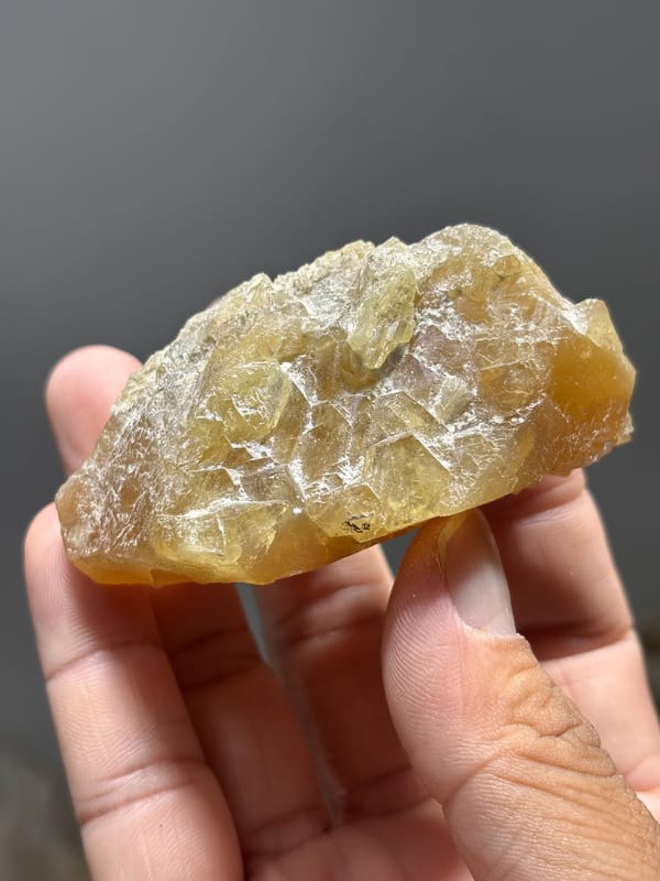 Honey scheelite dotted with white calcite crystals from Xuebaoding, Sichuan, China, close-up of the crystal faces