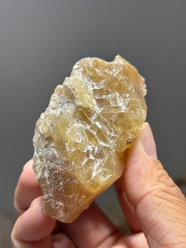 Honey scheelite dotted with white calcite crystals from Xuebaoding, Sichuan, China, reverse side