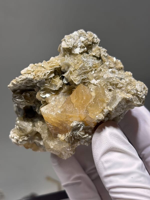Pale yellow scheelite plate with golden mica from Xuebaoding, Sichuan, China, close-up of the crystal faces