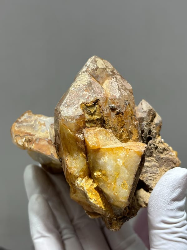 Tan cathedral quartz cluster on golden matrix from Xuebaoding, Sichuan, China, close-up of the crystal faces