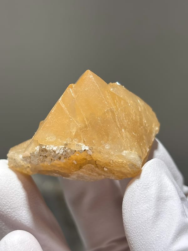 Honey-orange scheelite with complete tip from Xuebaoding, Sichuan, China, close-up of the crystal faces