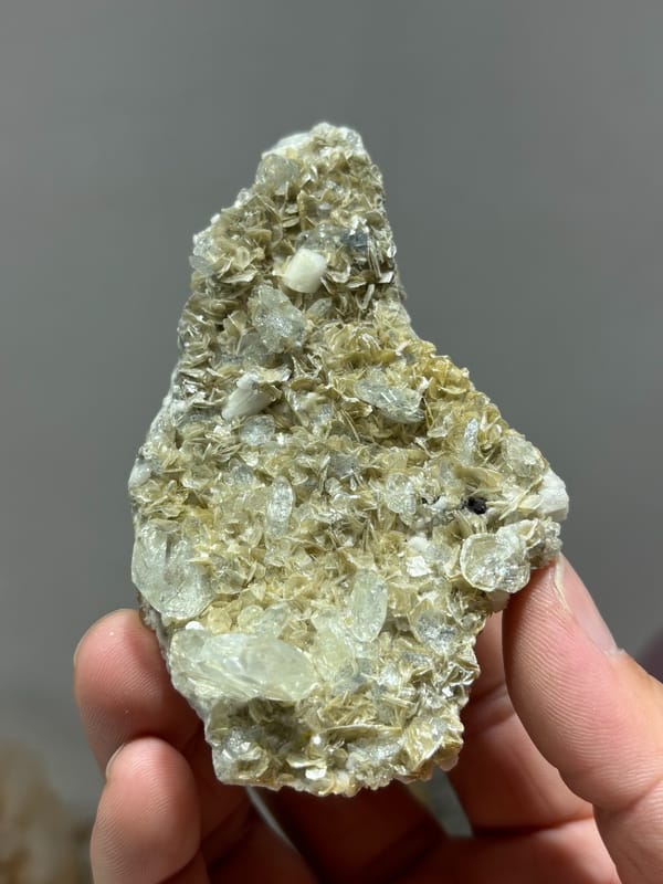 Mica plate with aquamarine grown on both faces from Xuebaoding, Sichuan, China, held in hand