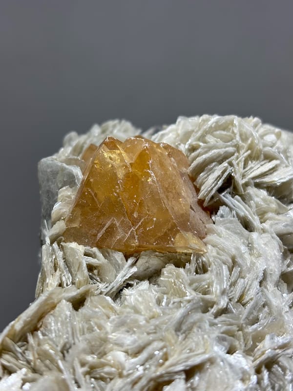 Orange scheelite in bed of tan mica from Xuebaoding, Sichuan, China, second angle