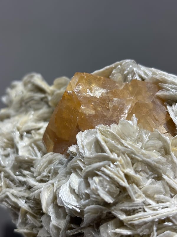 Orange scheelite in bed of tan mica from Xuebaoding, Sichuan, China, reverse side