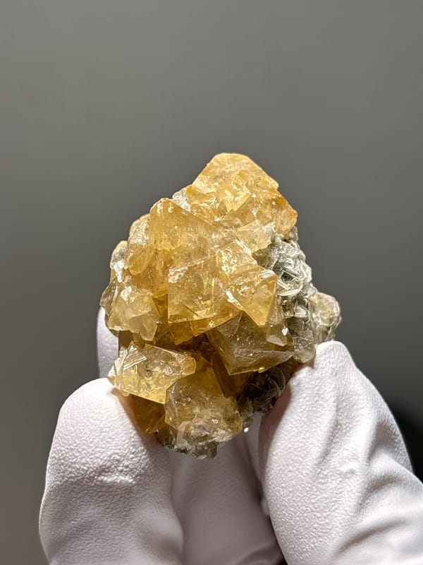 Golden scheelite cluster of intergrown crystals from Xuebaoding, Sichuan, China, close-up of the crystal faces