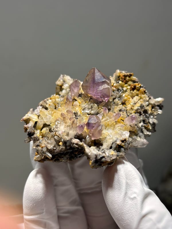 Purple amethyst points on druse plate from Zimbabwe, close-up of the crystal faces