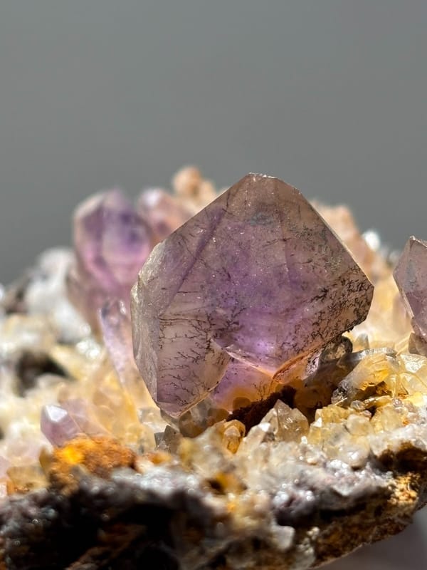 Purple amethyst points on druse plate from Zimbabwe, detail of the matrix contact