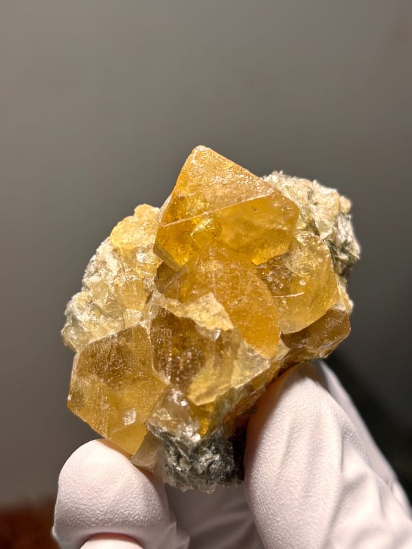 Golden scheelite cluster with mica from Xuebaoding, Sichuan, China, close-up of the crystal faces