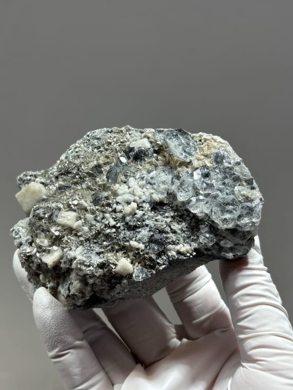 Grey plate with aquamarine, mica and feldspar from Xuebaoding, Sichuan, China, reverse side